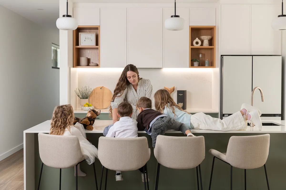 Family gathered around the island bench of a renovated kitchen